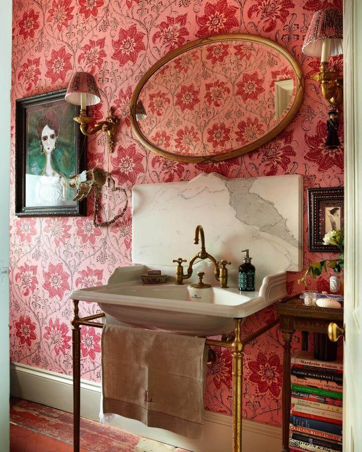 Pink floral wallpaper powder room with vintage brass sink and marble backsplash from @studiomunge. Cozy and elegant pink powder room ideas.