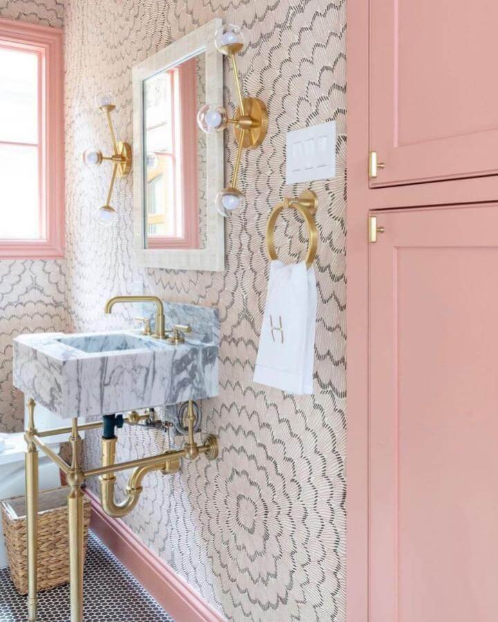 Pink cabinetry powder room with marble sink brass fixtures and geometric wallpaper from @palmer_industries bright and chic pink powder room ideas design.