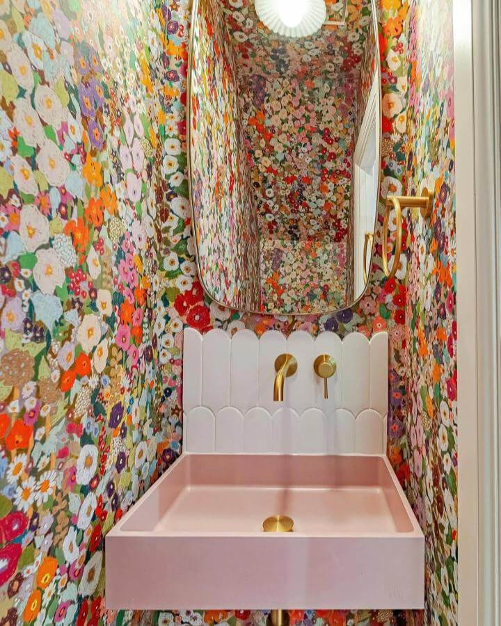 pink concrete sink and brass fixtures in floral wallpapered powder room from @muddconcrete with scalloped white tile backsplash pink powder room ideas