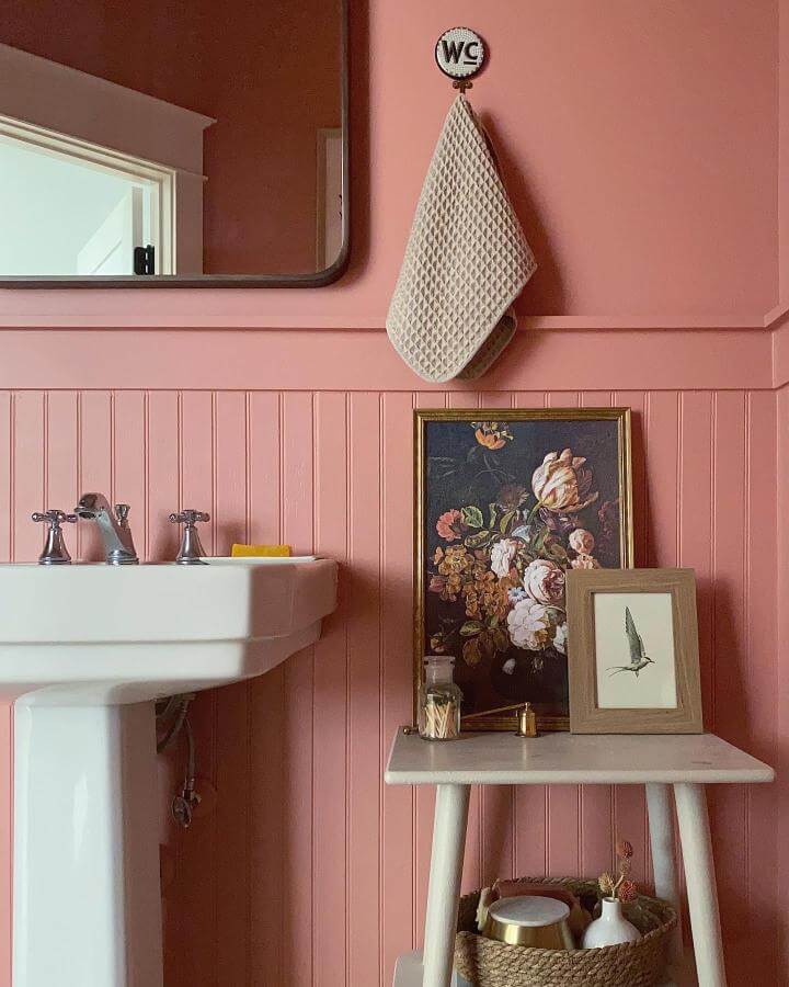 pink beadboard powder room with vintage art and marble table from @thegoodmanhouse. Cozy stylish pink powder room ideas with classic accents