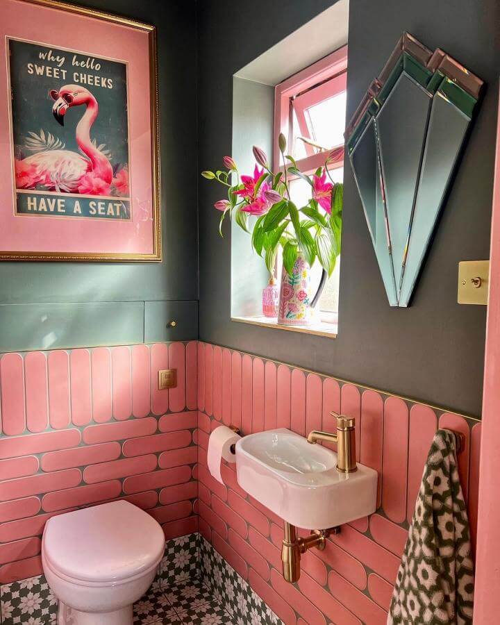 Pink rounded tile walls and vintage brass fixtures in a pink powder room ideas design from @karrbick_design with floral floor tiles and retro mirror.