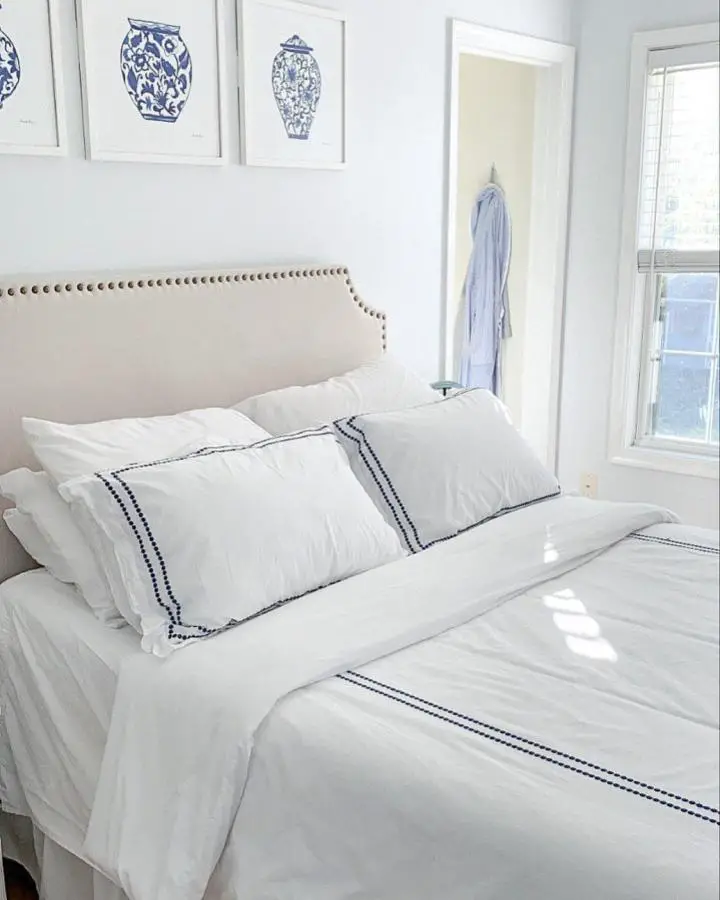 White bedding with navy trim from @theperennialprepster. Clean hotel-style linens with nailhead headboard.