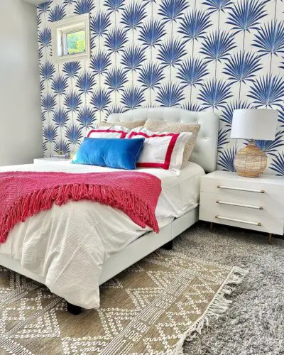 Blue and white palm wallpaper bedroom showcasing trendy preppy bedroom ideas from @authinteriors. Coral throw adds vibrant contrast.