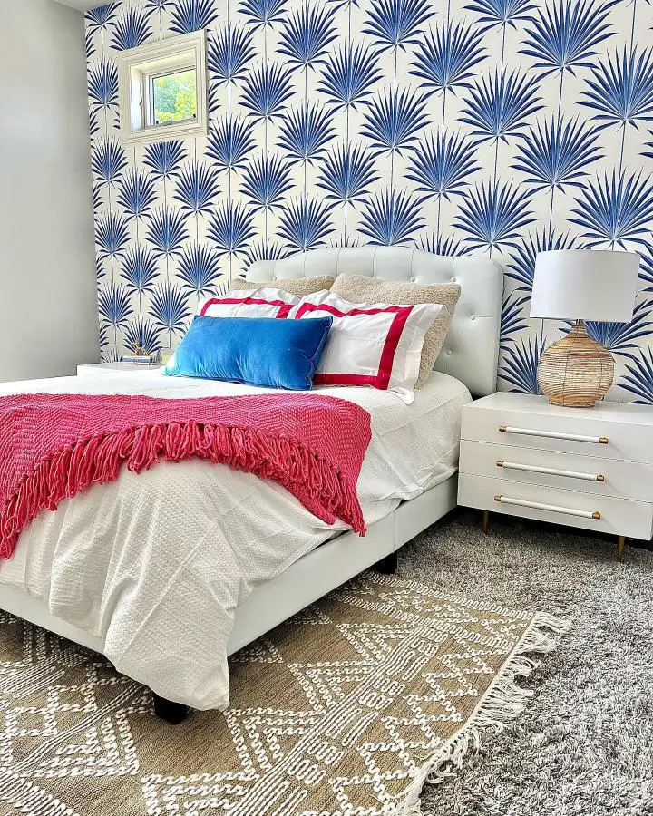 Blue and white palm wallpaper bedroom showcasing trendy preppy bedroom ideas from @authinteriors. Coral throw adds vibrant contrast.