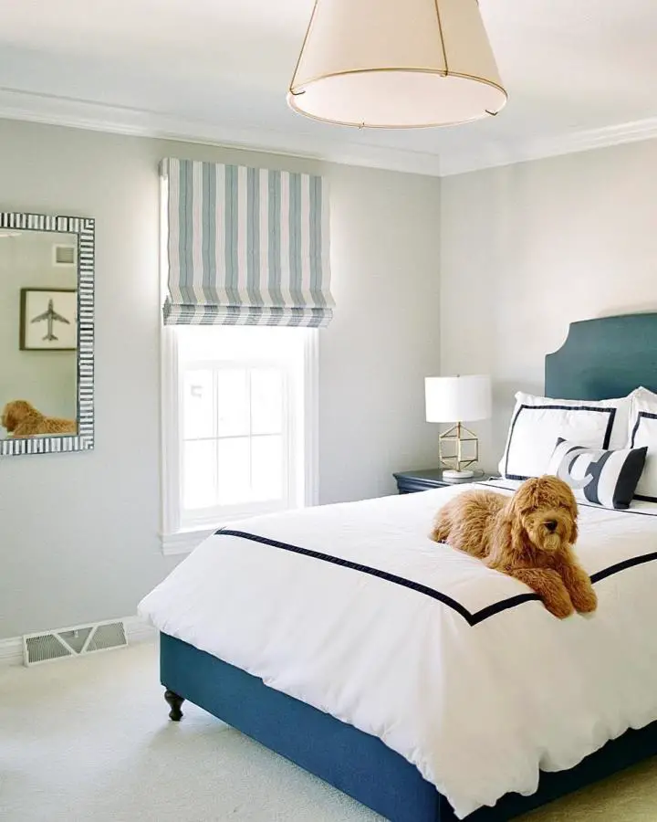 Teal upholstered headboard from @summit_drive_design. White bedding with navy trim and golden retriever.