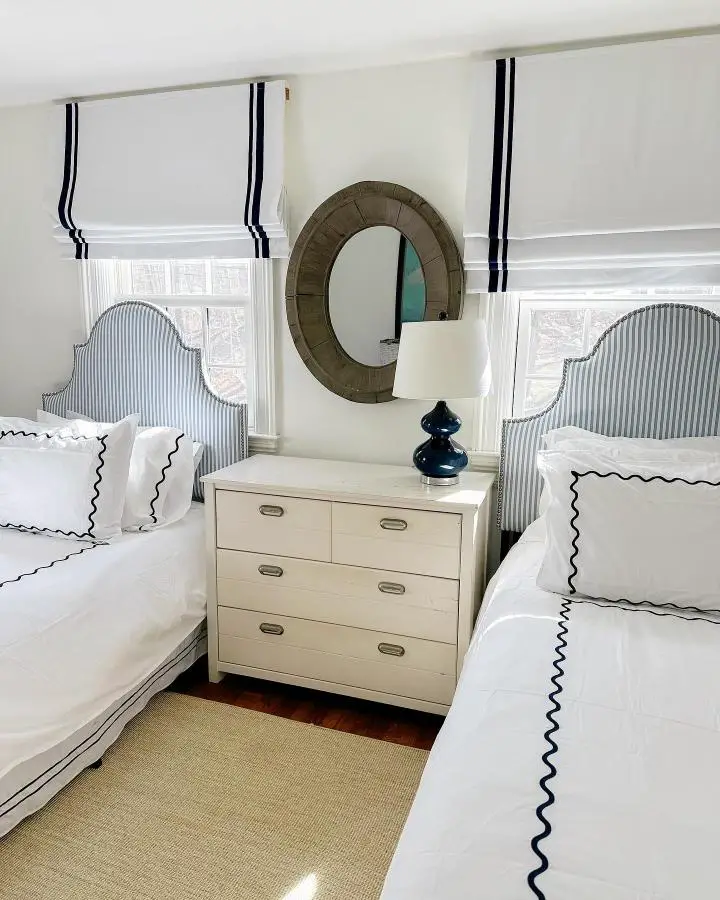 Cream campaign-style nightstand from @kristinmkennedy. Features brass hardware between striped headboard twin beds.