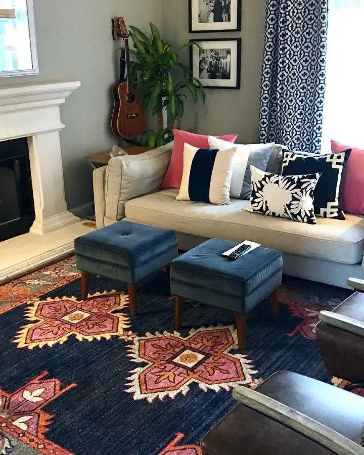 Navy blue tufted ottomans from @erinwestdesign showcasing symmetrical preppy living room ideas with geometric patterns.