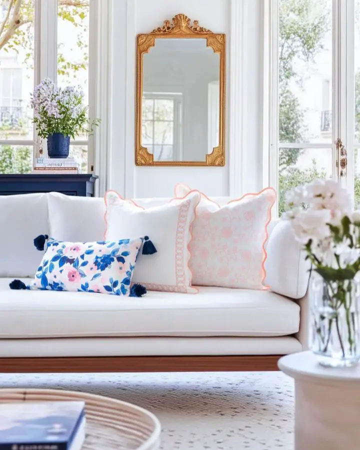 Ornate gold framed mirror from @hofdeco.official anchoring elegant white living room with floral accents.