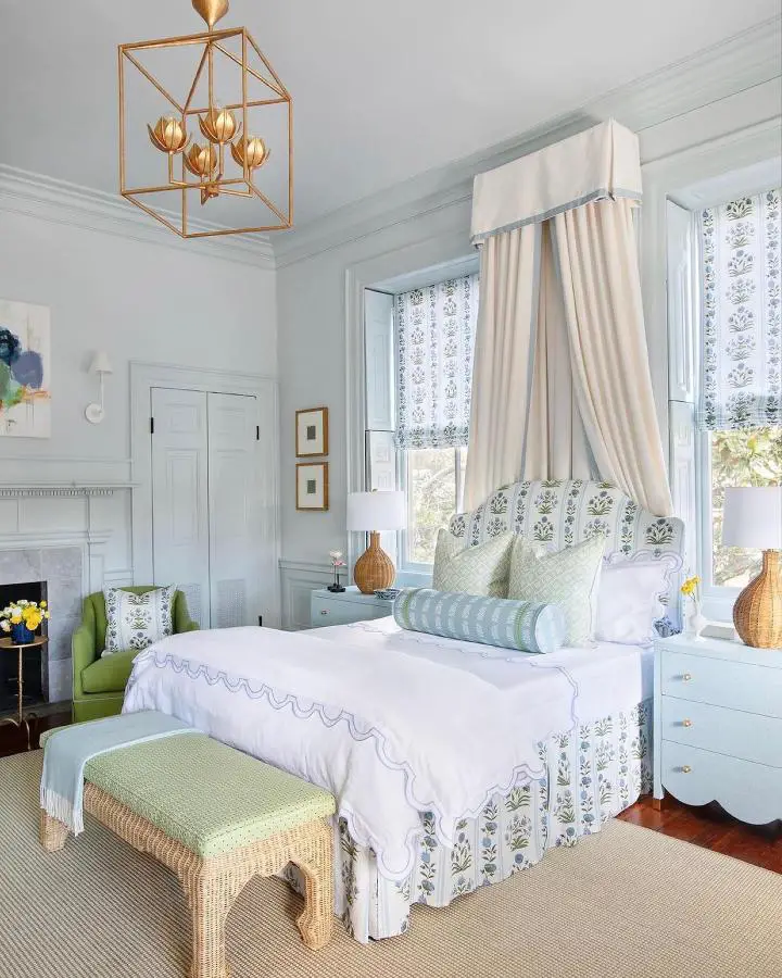 Soft cream canopy bed from @julieneilldesigns. Pale blue walls and white linens create serene atmosphere.