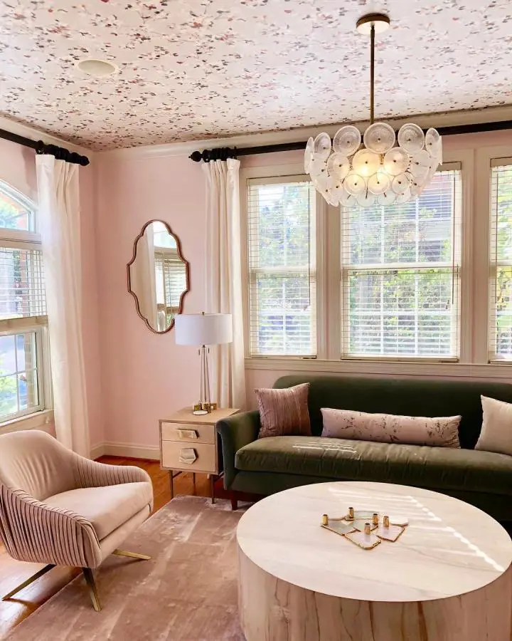 Floral ceiling wallpaper living room from @sabrinacabada showing pretty living room ideas with pink walls and green velvet sofa.