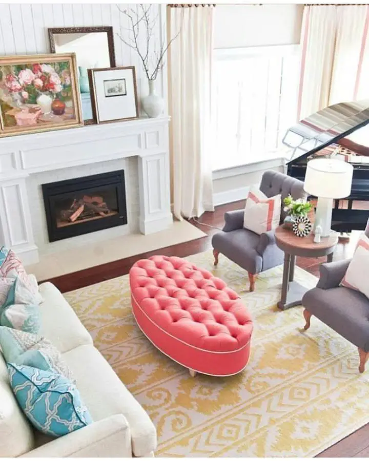 Coral tufted ottoman from @natashakalitadesign. Oval velvet centerpiece with button detailing on geometric rug.