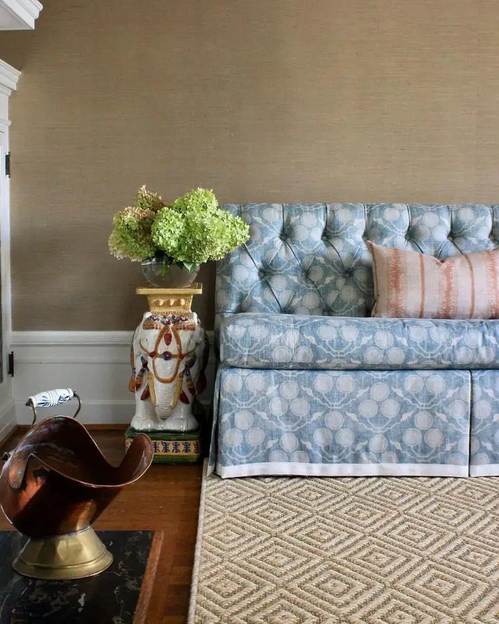 Powder blue tufted sofa from @brasshilldesign. Features button-tufted detailing and geometric patterned upholstery with leather accent pillows.