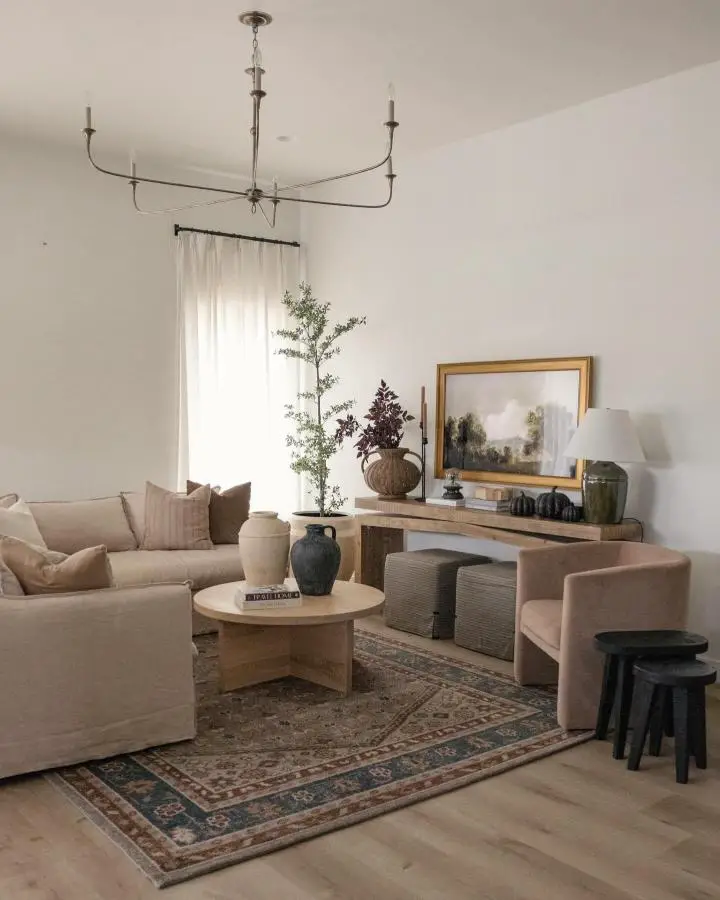 Warm neutral living room from @frengpartyof6. Features vintage patterned rug and natural linen furniture.