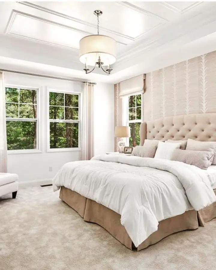 Cream drum pendant light fixture from @litadirksco. Soft lighting creates peaceful ambiance above neutral bedding and tufted headboard.