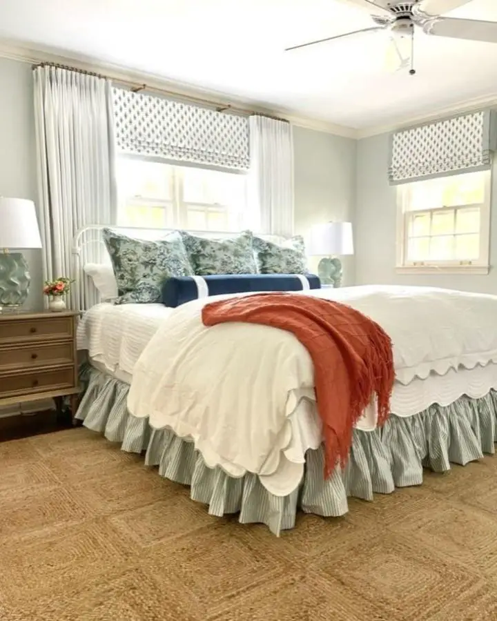 Layered window treatments bedroom from @agchomestyled. Roman shades with geometric pattern paired with flowing cream curtains.