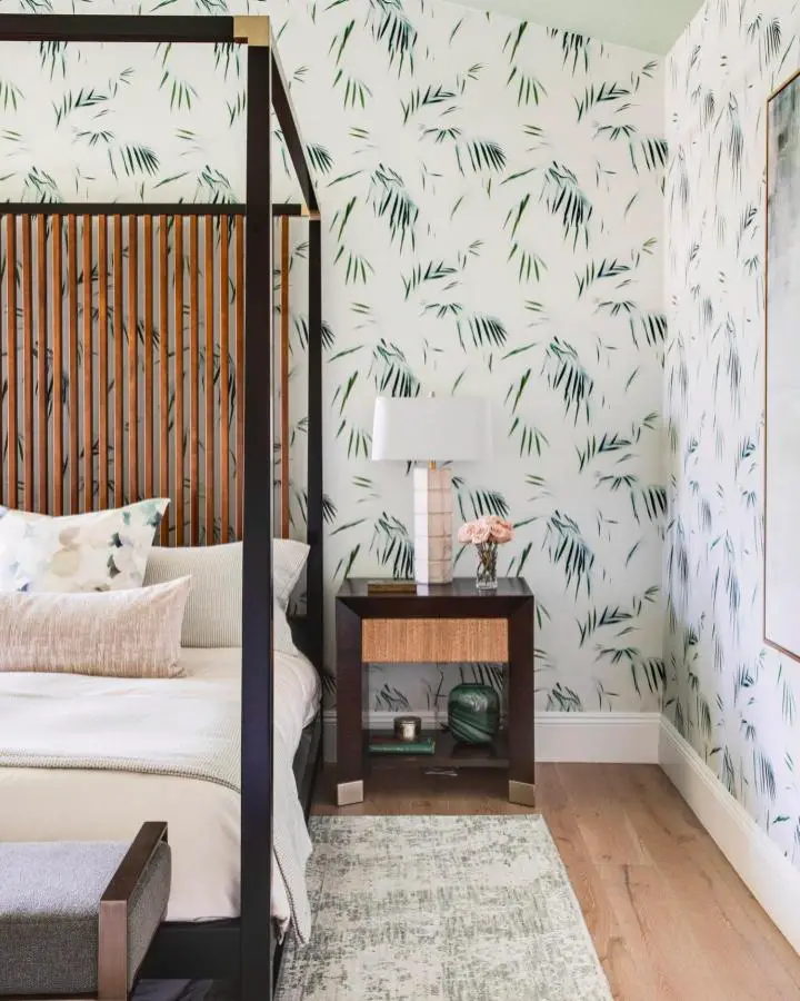 Palm leaf wallpaper bedroom from @mayawilliamsdesign. Four-poster bed with tropical botanical pattern and warm wood furniture.