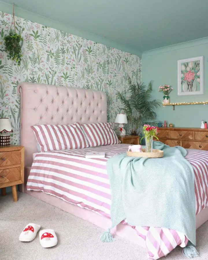 Botanical accent wall bedroom from @itszoeshome featuring sage green bedroom ideas with pink floral wallpaper and striped bedding.
