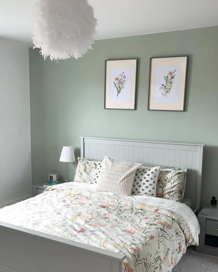 Fluffy white feathered pendant light from @kingswood_renovation perfectly complements sage green bedroom ideas with botanical bedding and framed artwork.