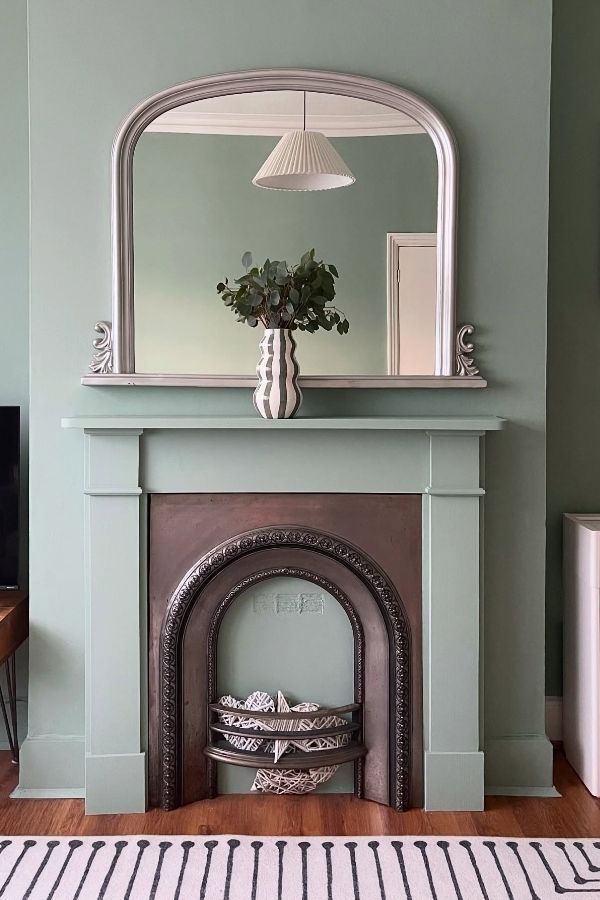 Sage green living room with arched mirror: elegant, modern, inviting decor. Sage green living room ideas.