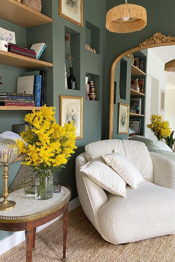 Sage green living room with gold mirror; elegant, cozy, serene decor.