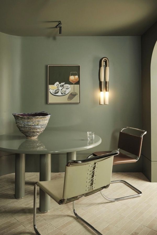 Sage green living room with sconce for modern, cozy ambiance; sage green living room ideas.