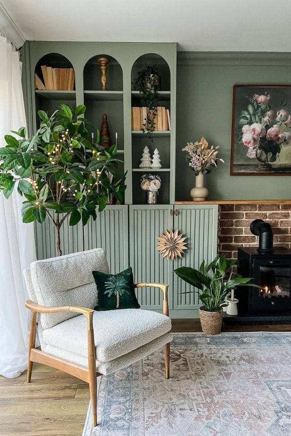 Sage green living room with cozy armchair; sage green living room ideas.