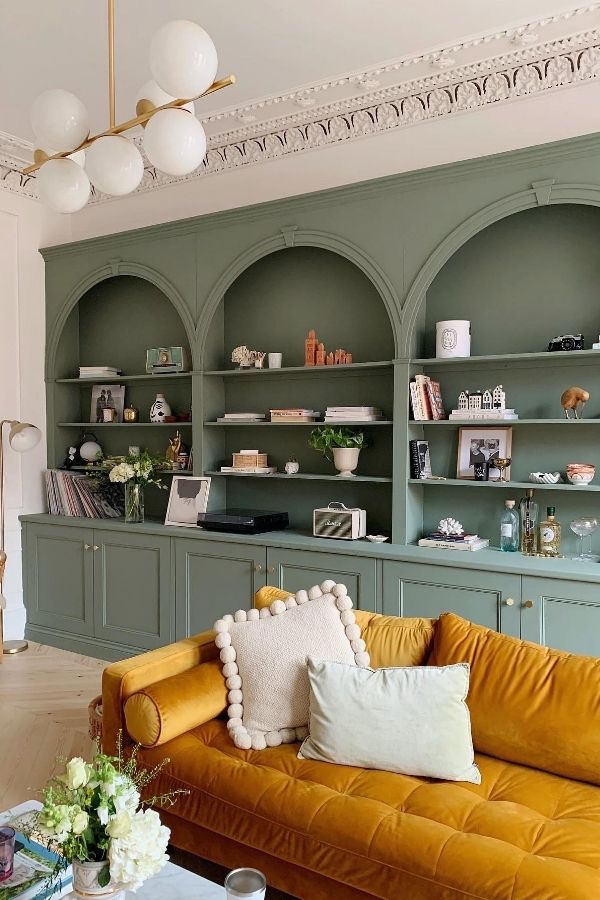 Stylish sage green living room with built-in shelving; sage green living room ideas.