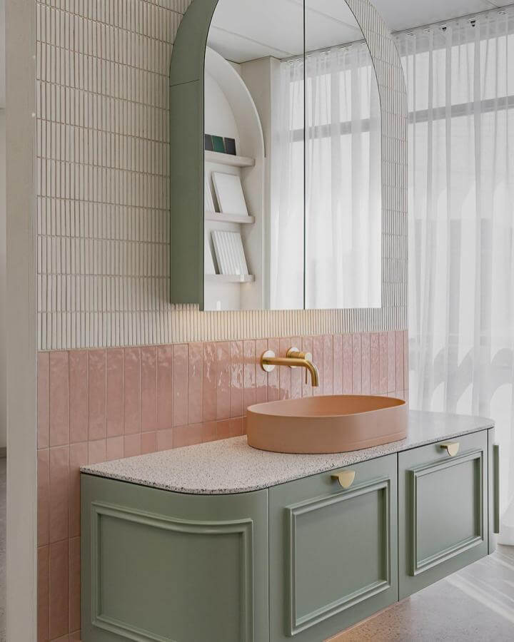 Sage green vanity with pink tile backsplash and brass fixtures in a bright powder room from @nood_co modern and elegant sage green powder room ideas