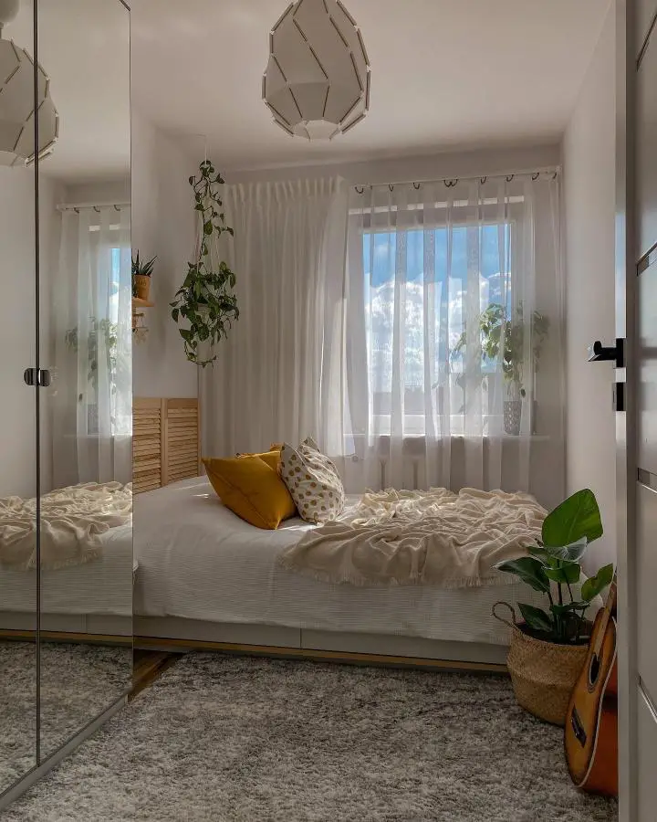 Modern white bedroom from @zrobieni_naszaro with floor-to-ceiling mirrored wardrobes and geometric pendant lighting.