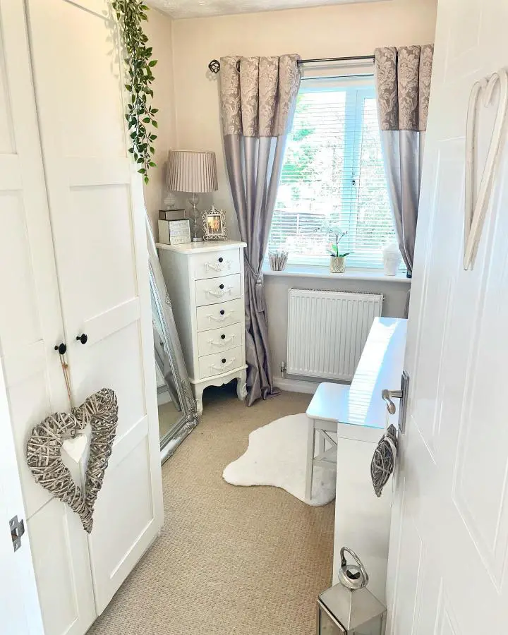 White chest of drawers positioned in corner next to window from @our_little_cosy_home. Multiple drawers provide compact storage solution.