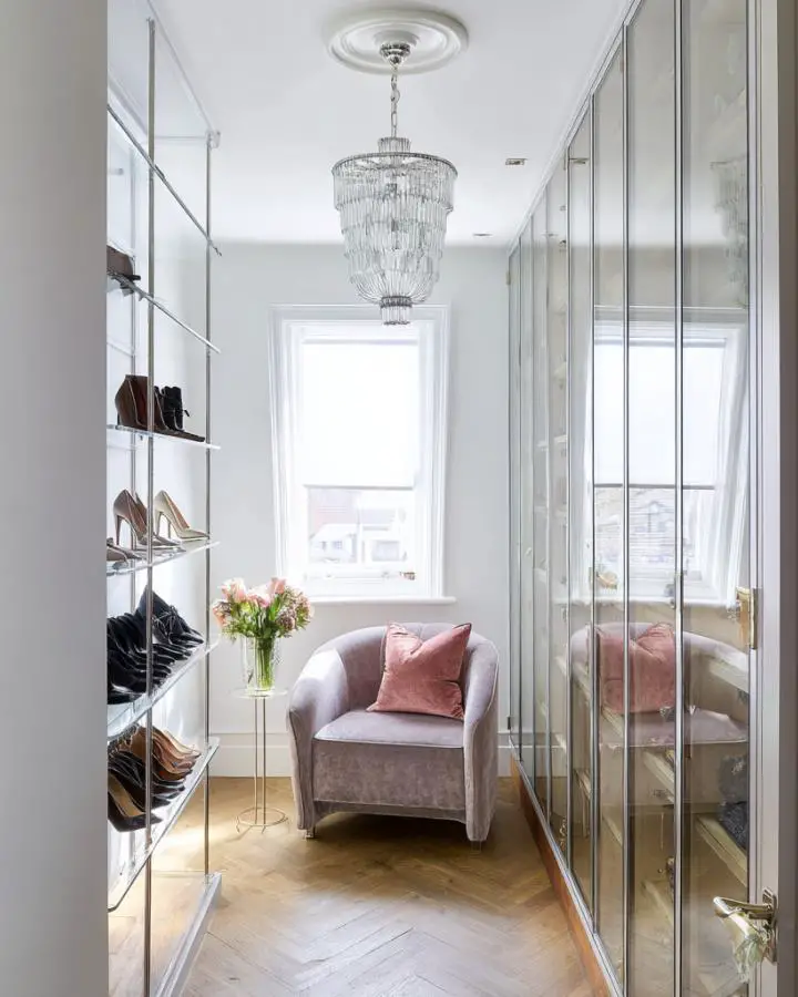 Elegant crystal chandelier dressing room showcasing small dressing room ideas with mirrored wardrobes and seating area.