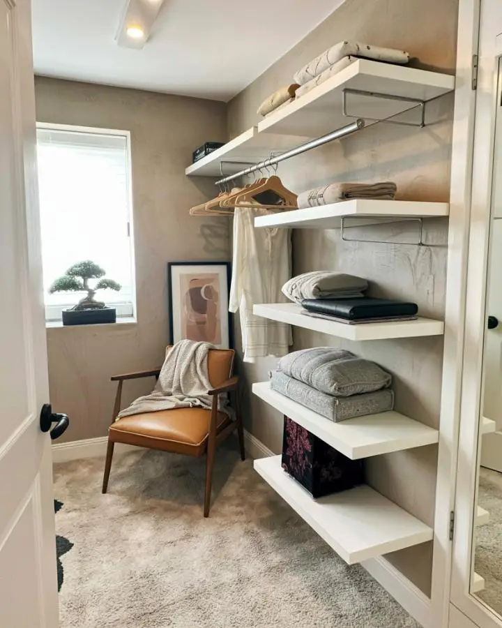 White open shelving system for small dressing room ideas with hanging rod and folded clothing storage.