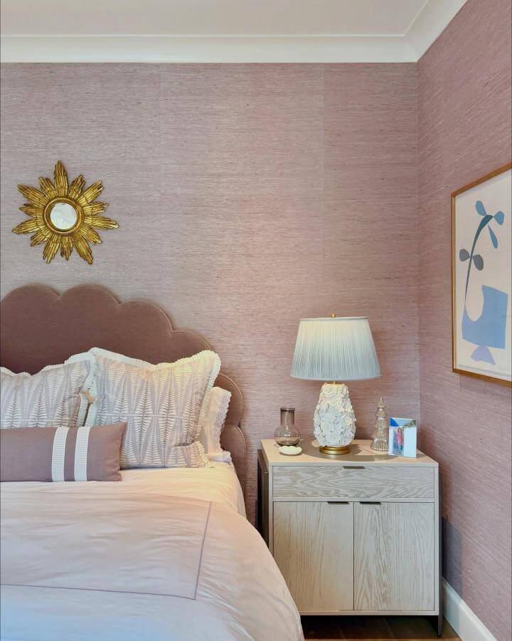 Soft lavender velvet headboard and textured wallpaper in cozy bedroom by @kfogara with warm wood tones and elegant lighting.