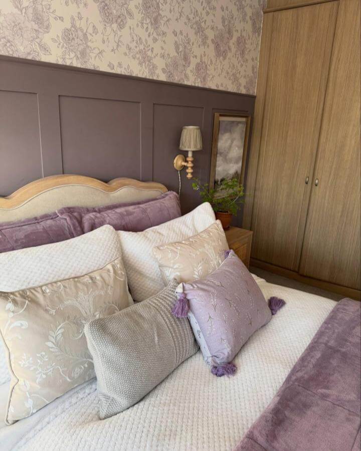 Soft lavender and cream bedroom with floral wallpaper and textured pillows from @jane_redrow_home showcasing cozy and elegant vibes.