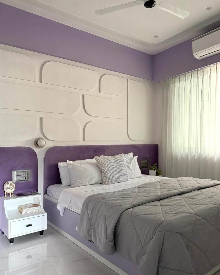 Soft lavender bedroom with geometric white textured headboard and plush bedding from @kahaanidesignstudio. Light-filled peaceful vibe.