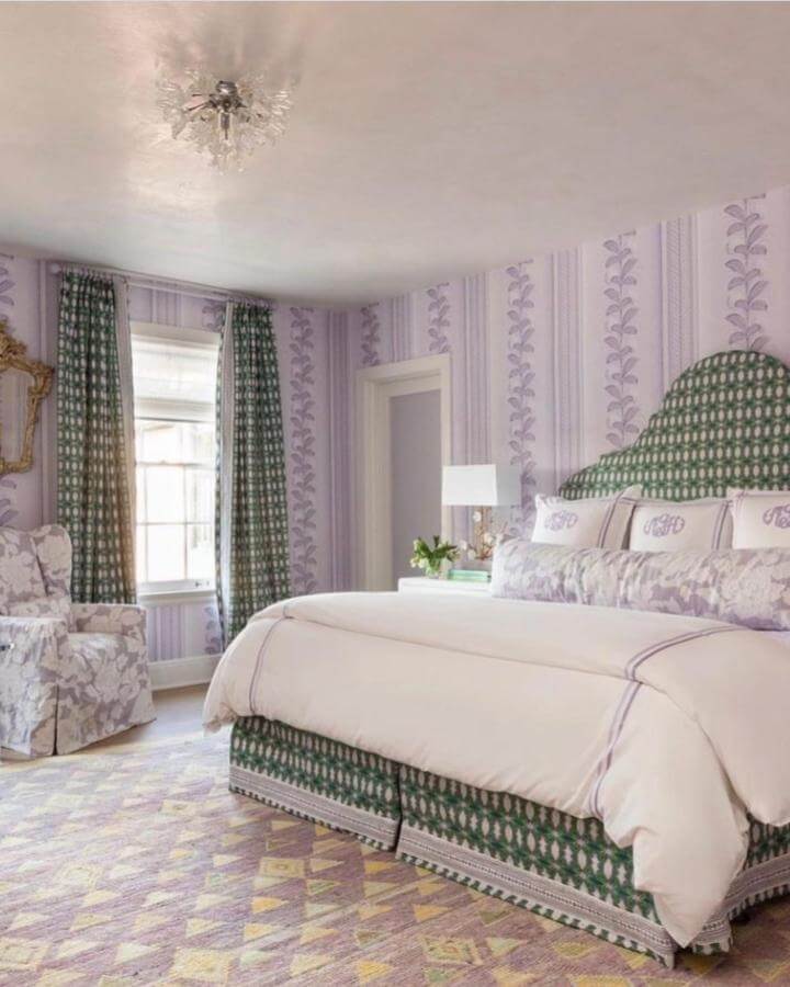 Soft lavender walls and green patterned accents create a cozy soft lavender bedroom ideas space from @schumacher_gulfcoast.