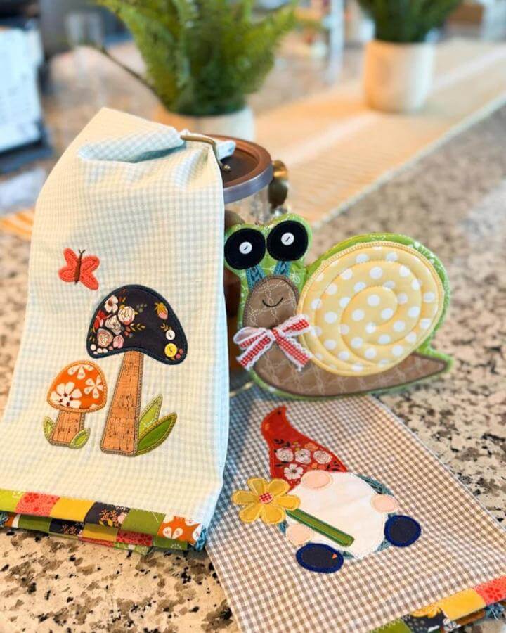 Gingham fabric with floral mushroom and snail appliqué for spring crafts for adults by @mygirlfriendsquiltshoppe. Bright and cozy handmade kitchen linens.