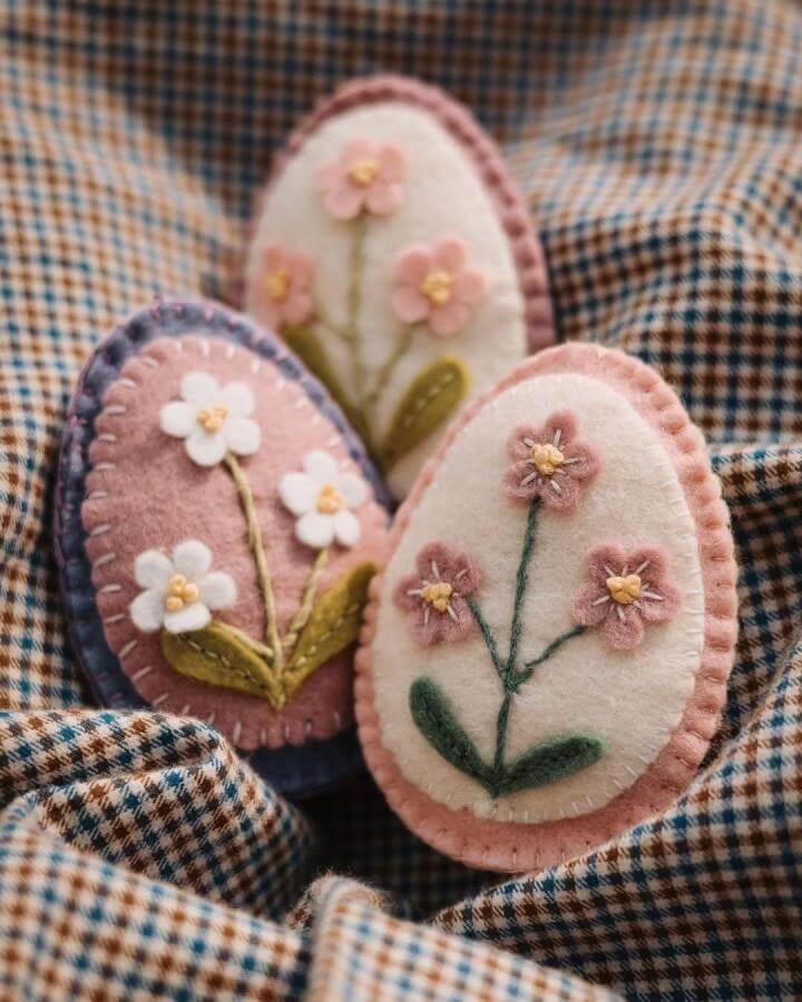 Soft pastel felt eggs with embroidered spring flowers on checkered fabric by @waldorfkluntjes spring crafts for adults handcrafted decoration.