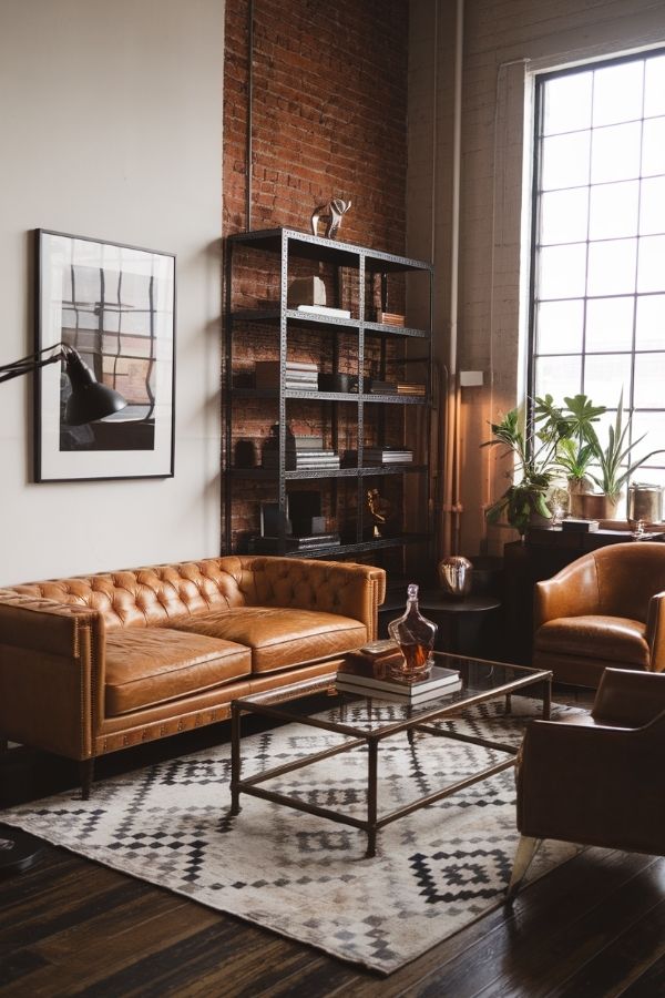 Modern tan leather couch in cozy, sunlit living room setting.