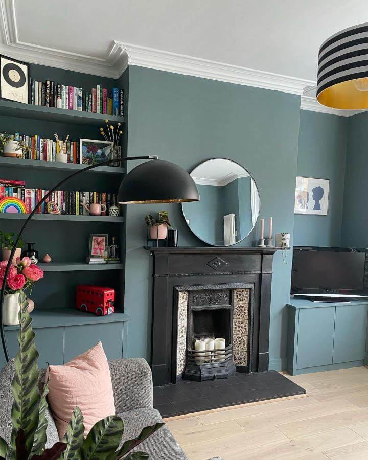 Teal painted living room from @renovating_no_39_liverpool with built-in shelves and black fireplace showing cozy teal living room ideas.