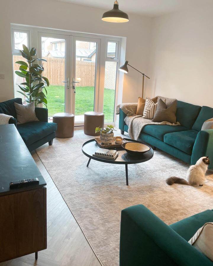 Teal velvet sofas in a bright living room by @designedwithdaniela with cozy textiles and natural light.
