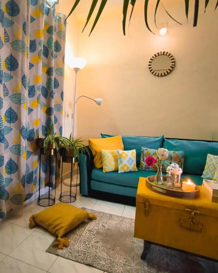 Teal and mustard accented living room with patterned curtains and cozy decor from @preshez_creationz. Vibrant and warm atmosphere.