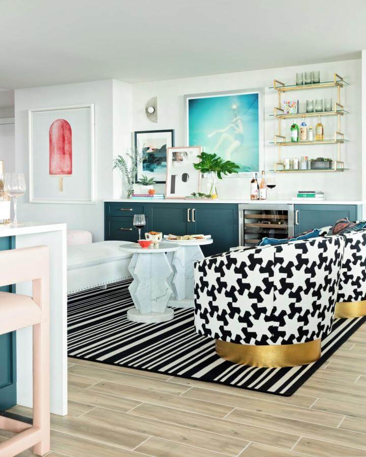 Teal cabinetry and black white patterned chairs from @lisagilmoredesign create a lively and elegant living room vibe.