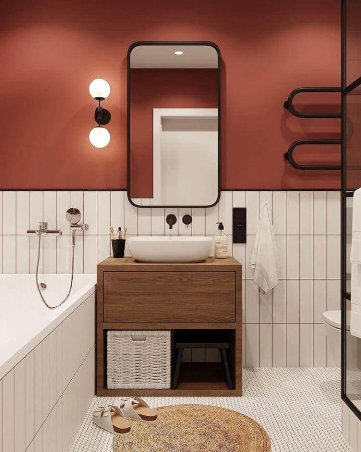 Warm terracotta walls, white tile, and natural wood vanity create cozy terracotta bathroom ideas by @coppeldesign.