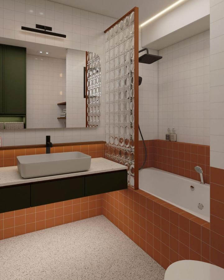 Burnt orange terracotta tile bathroom with glass partition and dark green cabinetry by @homeguideinterior modern earthy design.