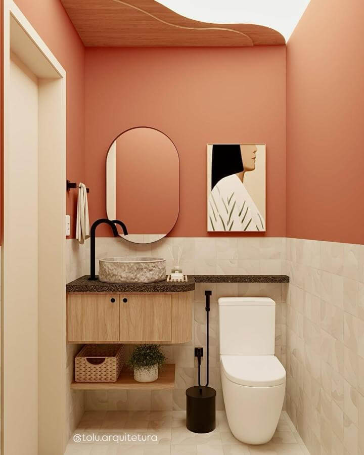 Terracotta painted bathroom walls with minimalist wooden vanity and stone sink by @tolu.arquitetura in warm earthy tones.