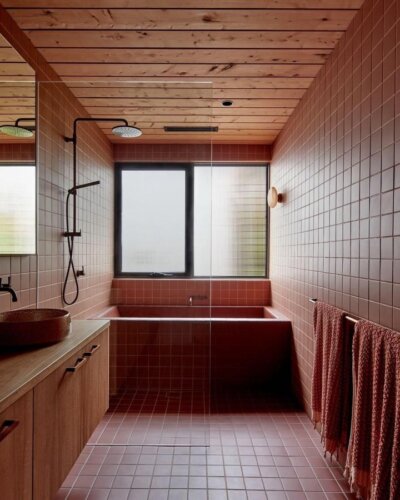 Terracotta-tiled bathroom with wood ceiling and black fixtures by @willem_dirk showing warm minimalist bath design.
