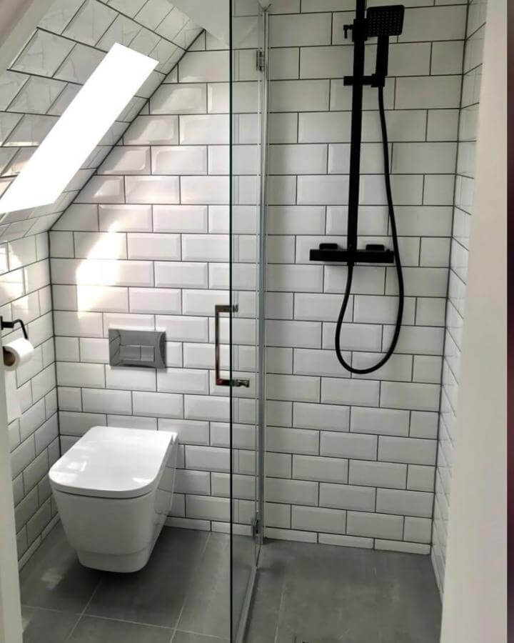 White subway tile bathroom with glass shower walls and black fixtures from @classicwithatwist_home showing bright tiny apartment bathroom ideas with clean modern style.