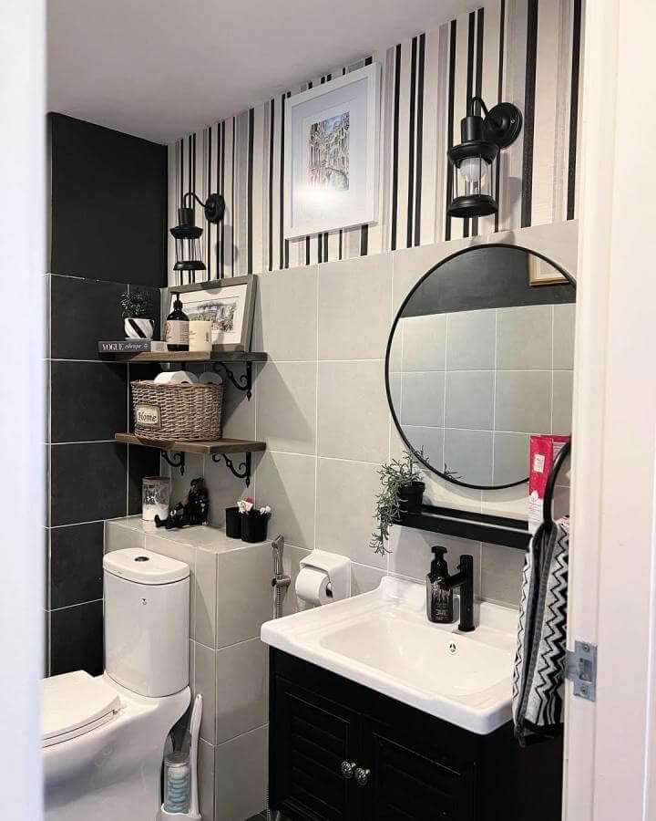 Black and white striped wallpaper bathroom with wood shelves and black fixtures from @home_decor_no4. Compact and stylish urban bathroom design.