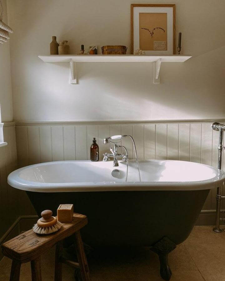 soft sage wainscoting and black clawfoot tub in Victorian bathroom ideas by @ferninteriors__ with vintage faucet and rustic decor